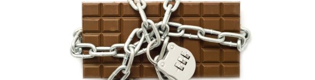 chocolate in chains and under lock and key on a white background